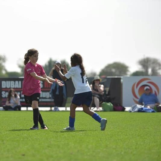 group of women playing soccer during daytime