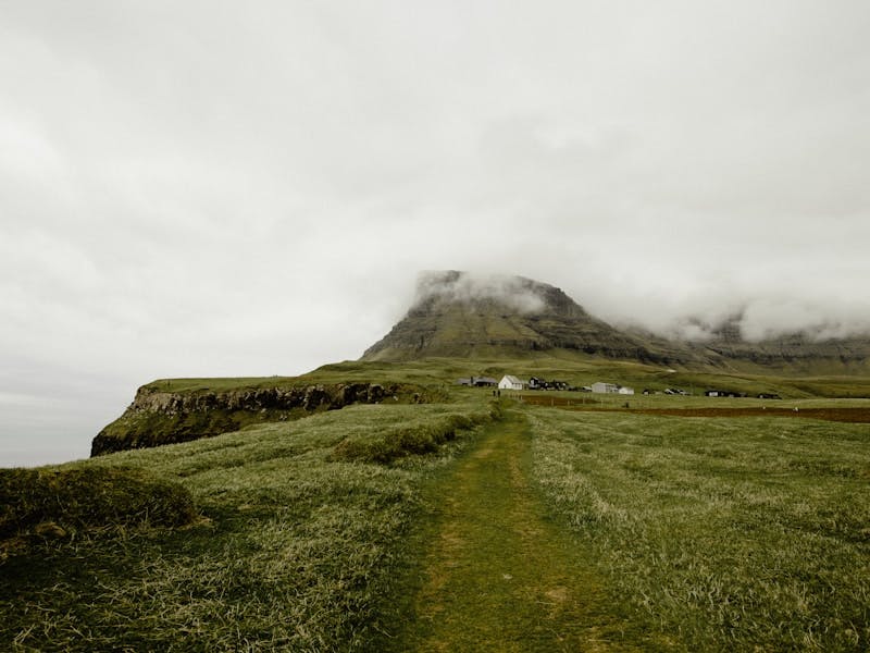 green grassland across clouded mountain