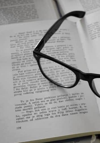 black framed eyeglasses on white printer paper