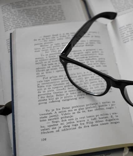 black framed eyeglasses on white printer paper