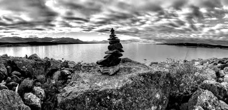 gray stones stacked with a serene lake in the background
