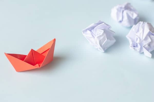 A red paper boat with white crumpled paper