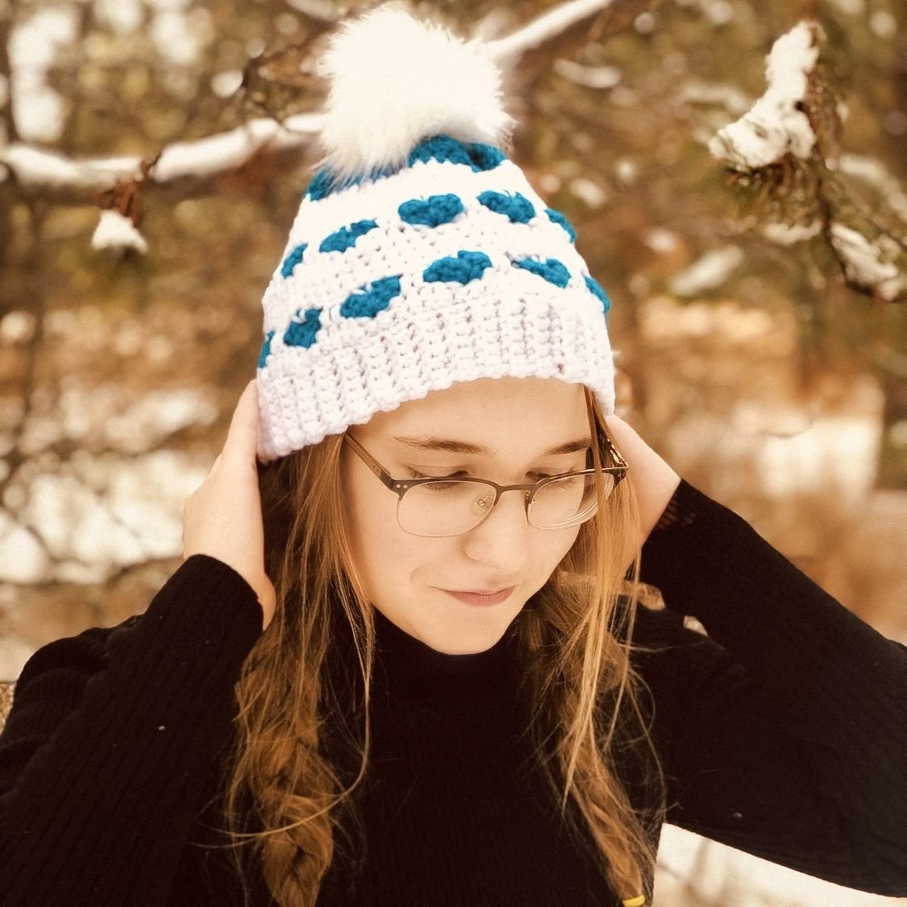 Handmade crochet beanie flatlay featuring a textured heart motif in soft, neutral tones.