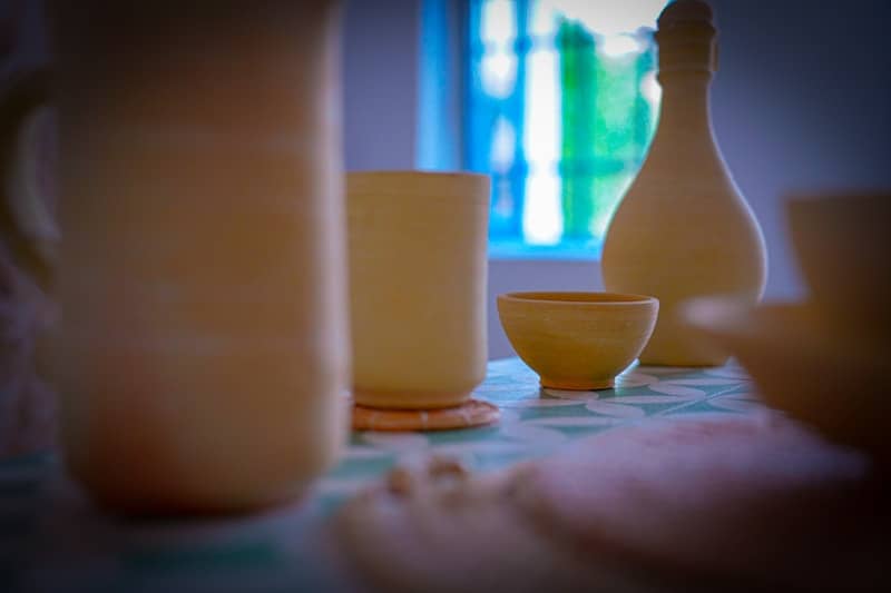 Yellow ceramic pitchers and bowls on a table.