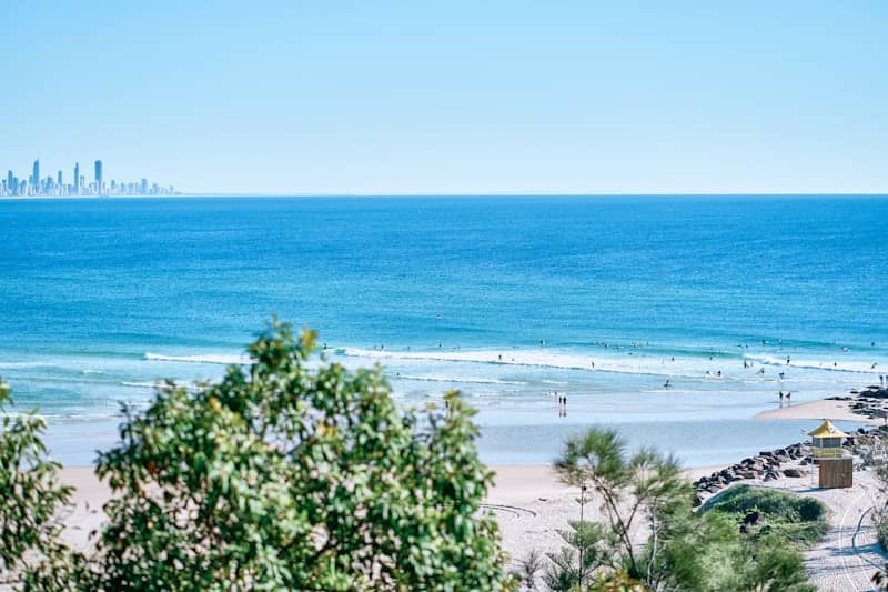 Beach scene with distant city skyline and ocean waves