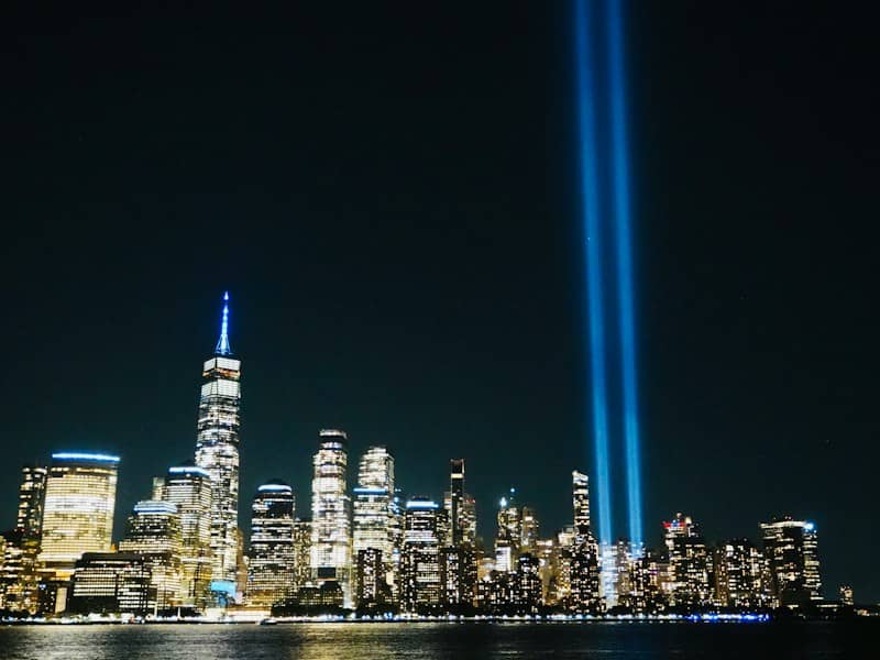 The Tribute in Light beams rising above the illuminated New York City skyline at night