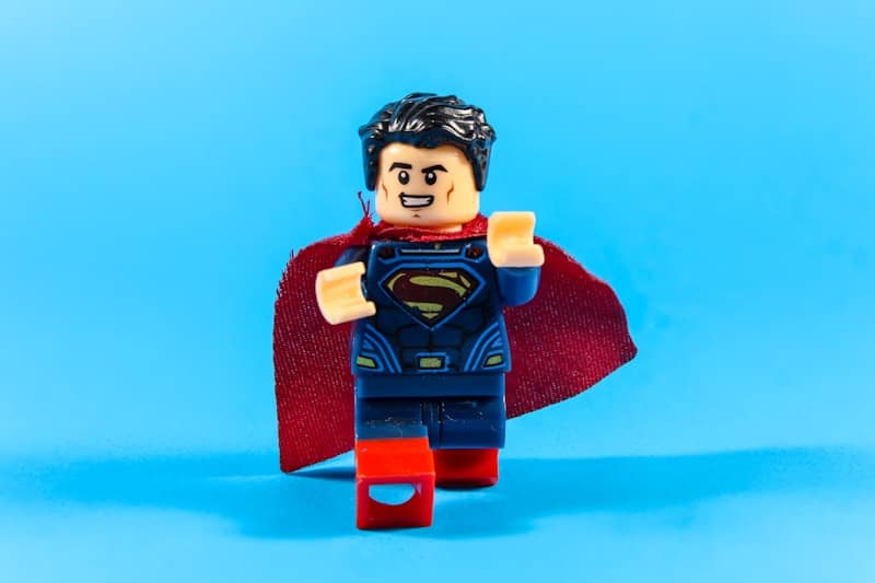 Superman lego figure with red cape on blue background