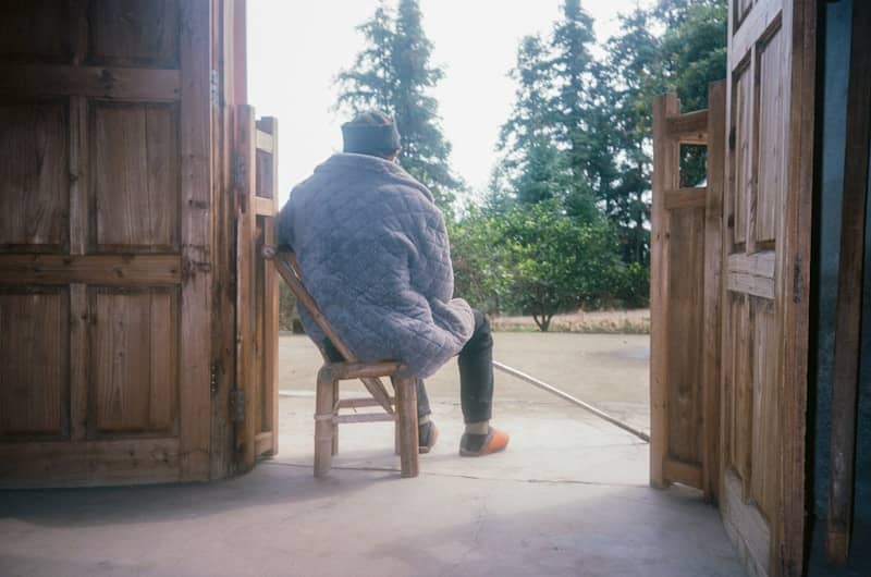 Person sitting on chair looking out doorway