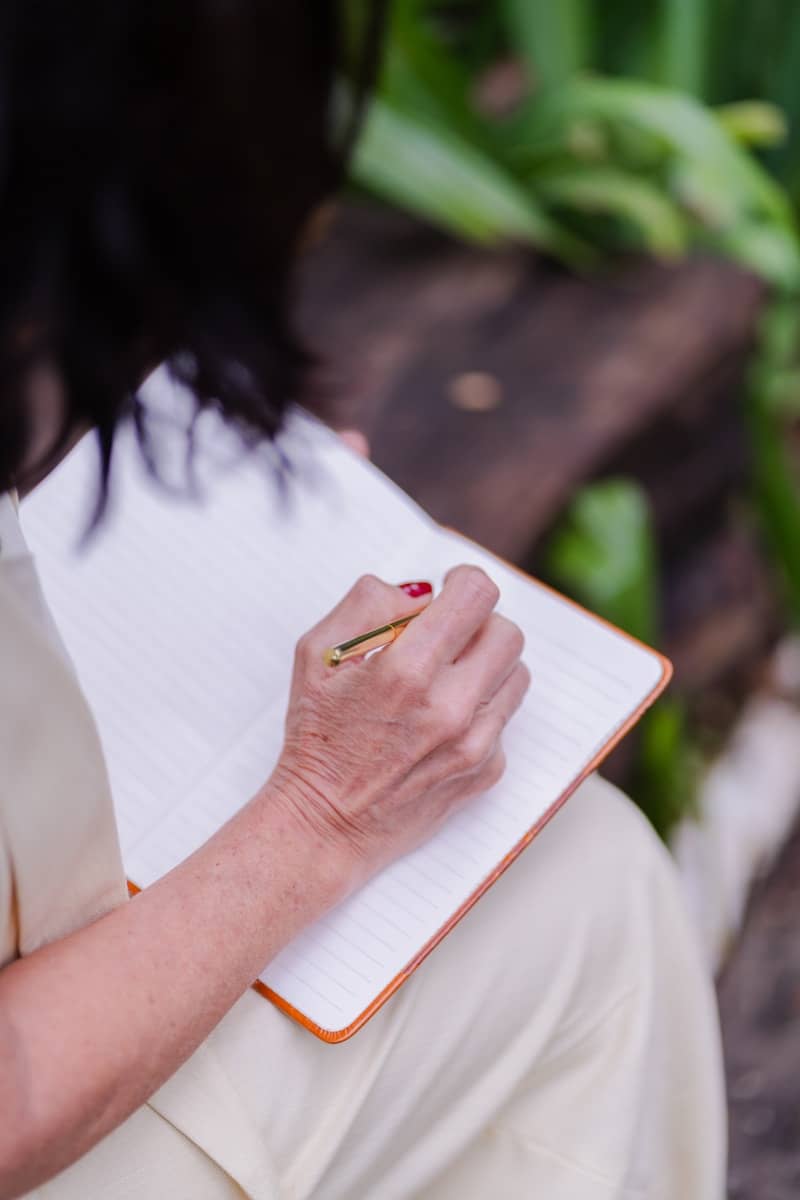 Woman writing in a notebook outdoors