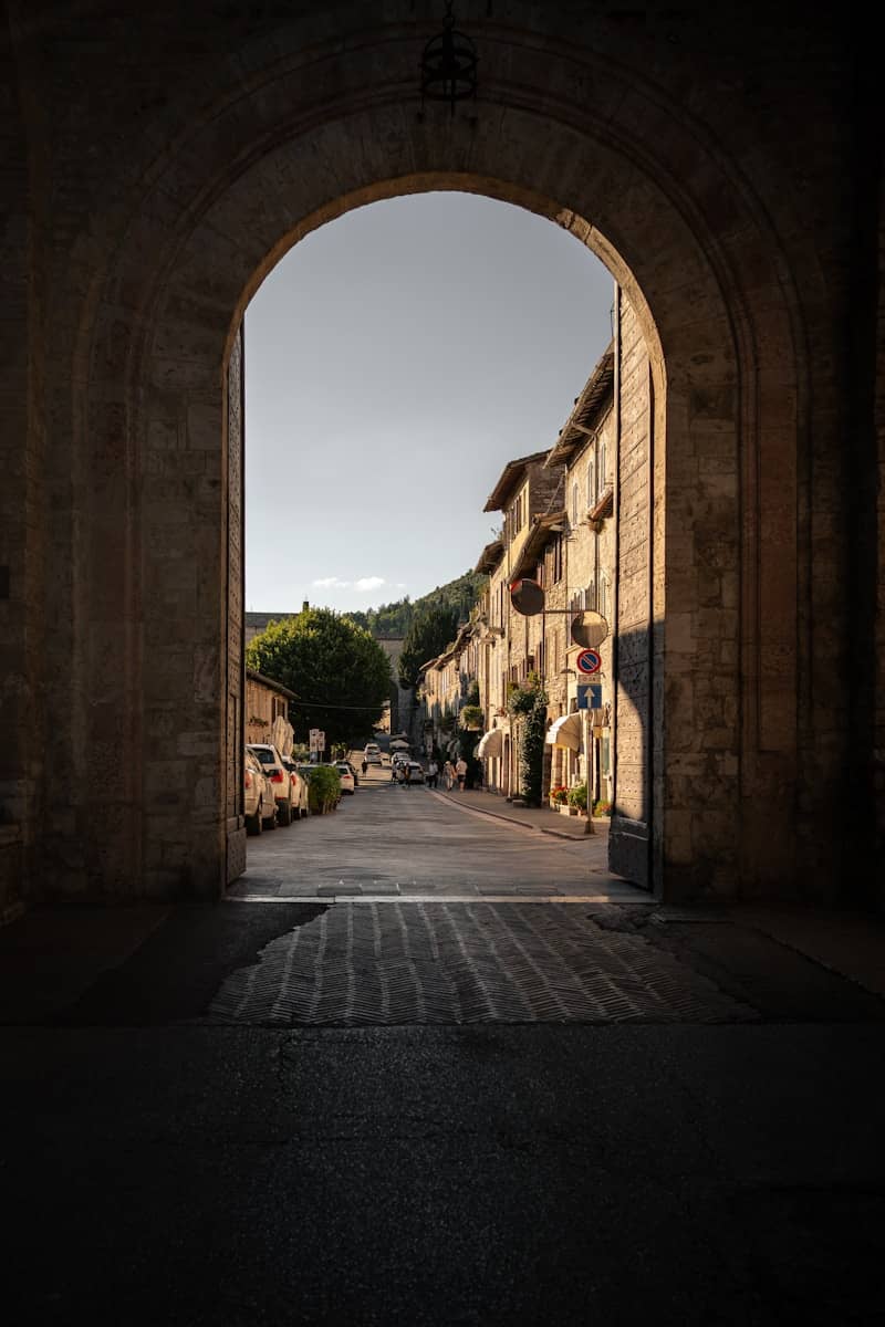 View through stone archway of a sunlit european street.