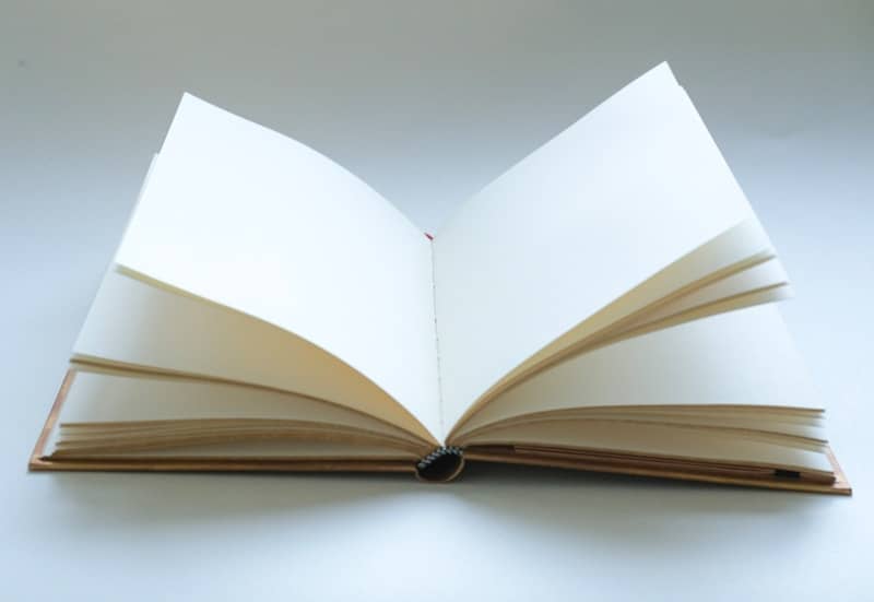 An open book with blank pages is visible.