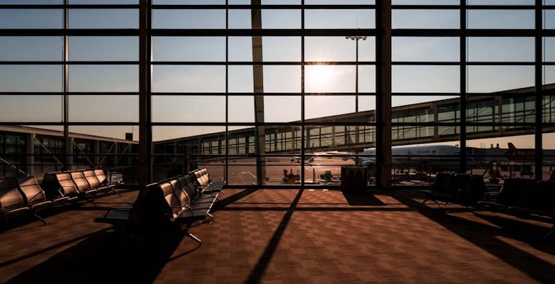 Airport terminal with seating and jet bridges at sunset