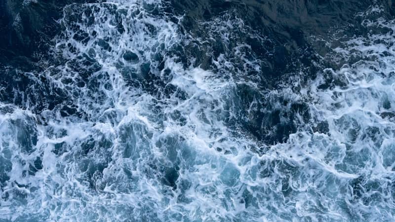 Churning ocean waves with white foam and dark blue water