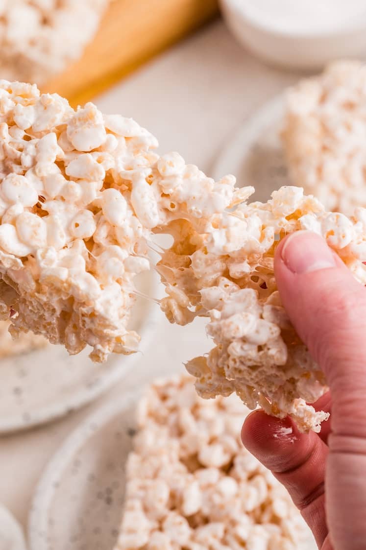 A hand pulling apart a Rice Krispie treat.