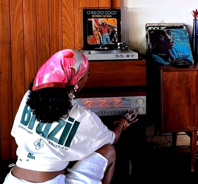 Black woman playing music on a stereo
