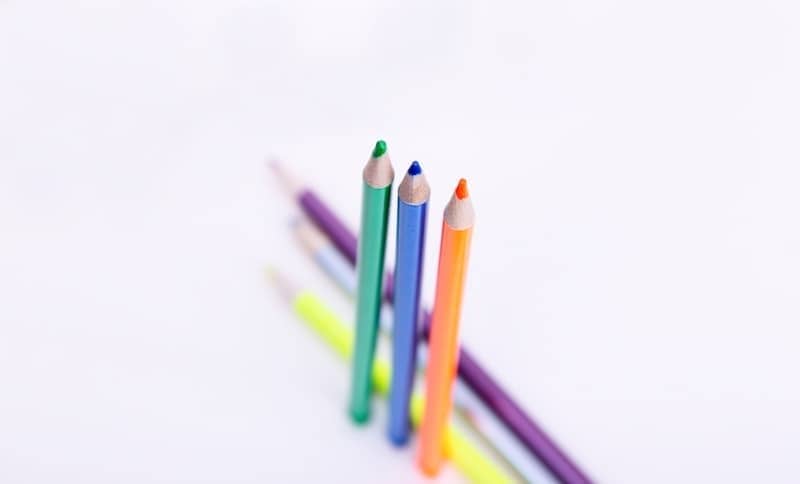 a row of colored pencils sitting next to each other
