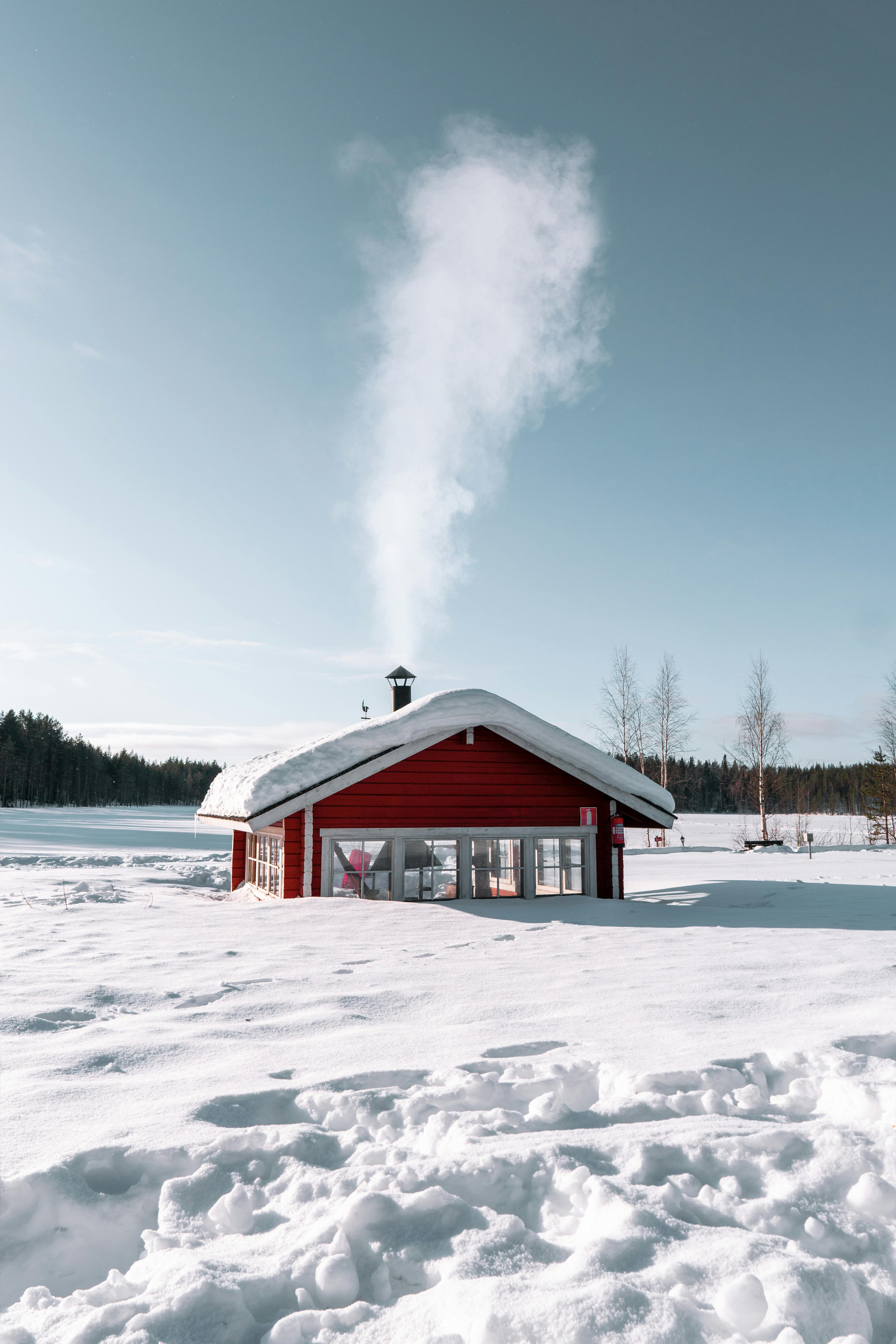 A cloud of wood smoke rising from a chimney in a winter neighborhood, illustrating air pollution concerns