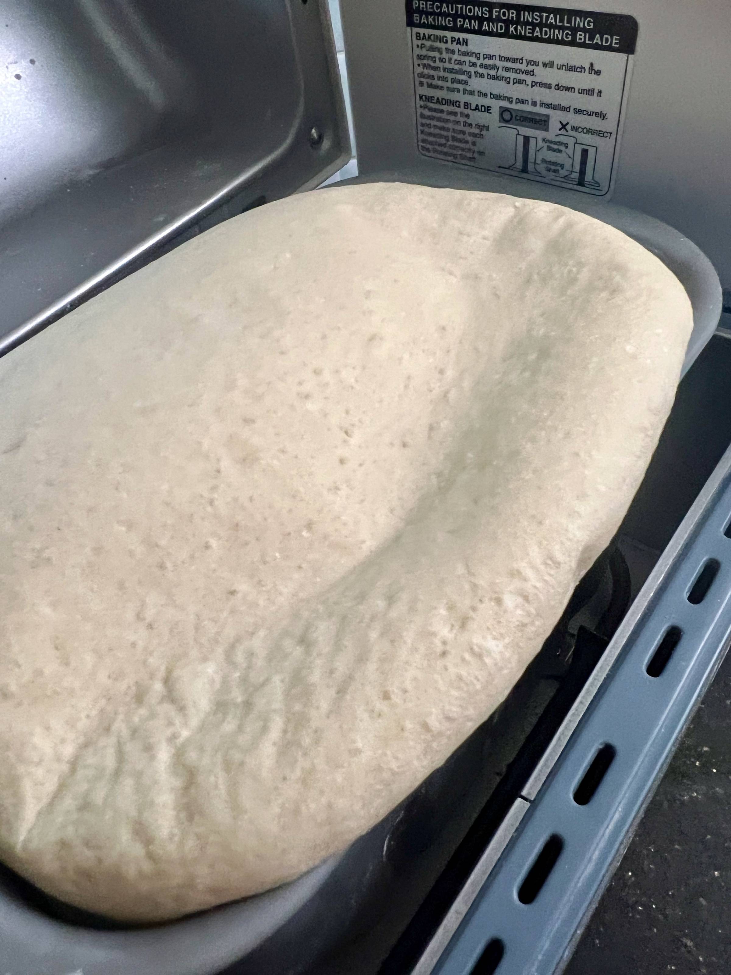 dough rising out of the bread machine pan