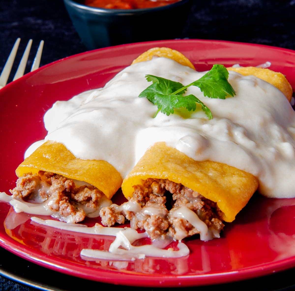 two green chile enchiladas on a plate ready to eat