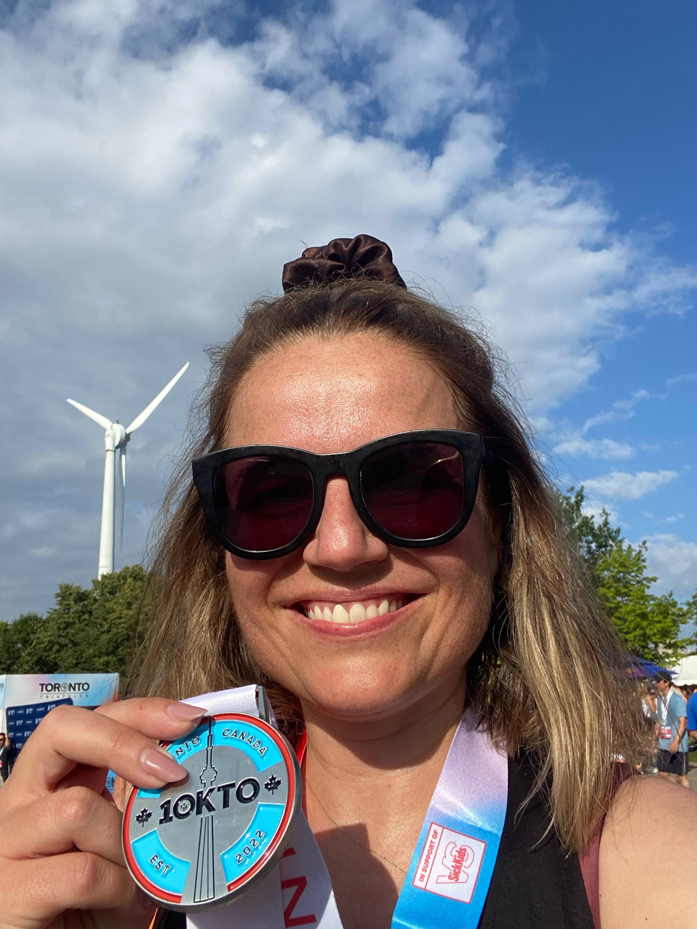 woman holding medal that says 10KTO