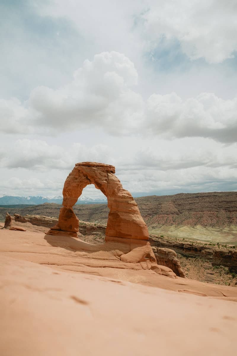 Delicate arch stands strong beneath cloudy skies.