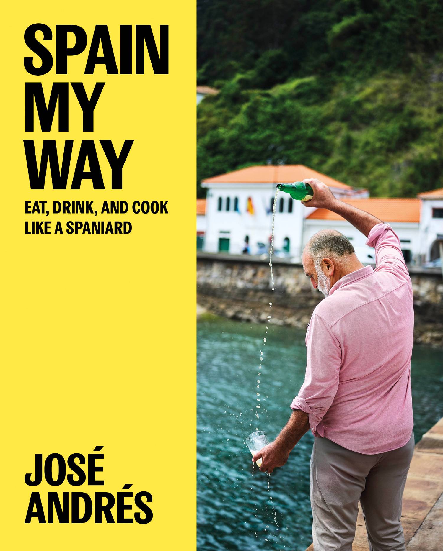 The bright yellow book jacket of Spain My Way by José Andrés, with a coastal Spanish scene on the cover and bold black typography.