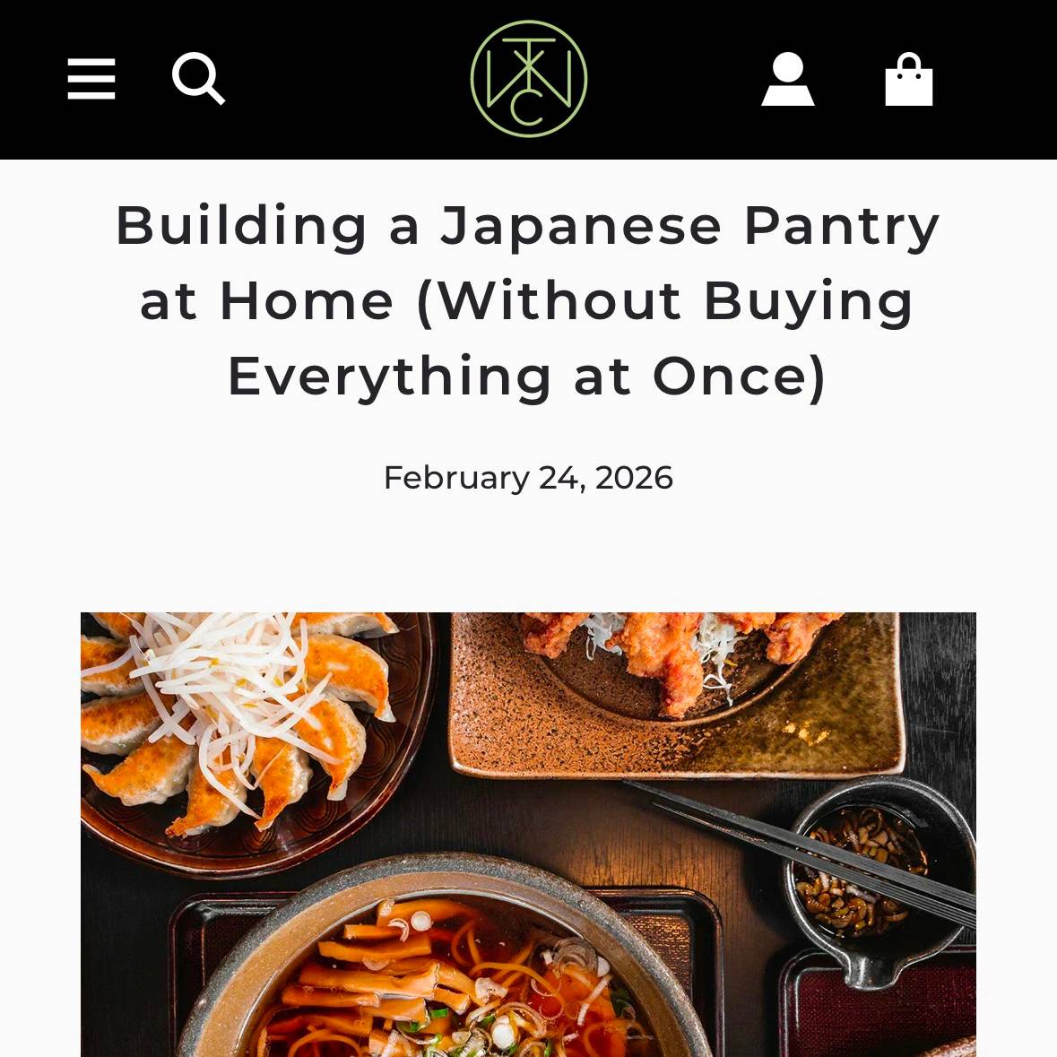 Assorted Japanese dishes and ingredients on a table including dumplings, noodles and dipping sauce