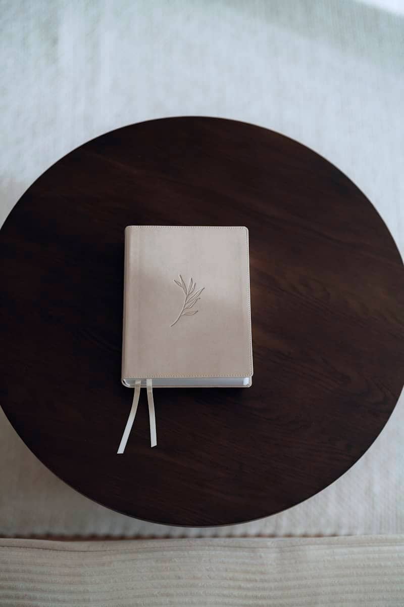 A closed white journal with a twig embossed on cover.