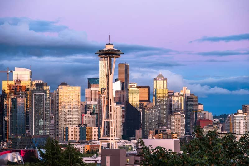 Seattle cityscape with space needle against a colorful twilight sky.