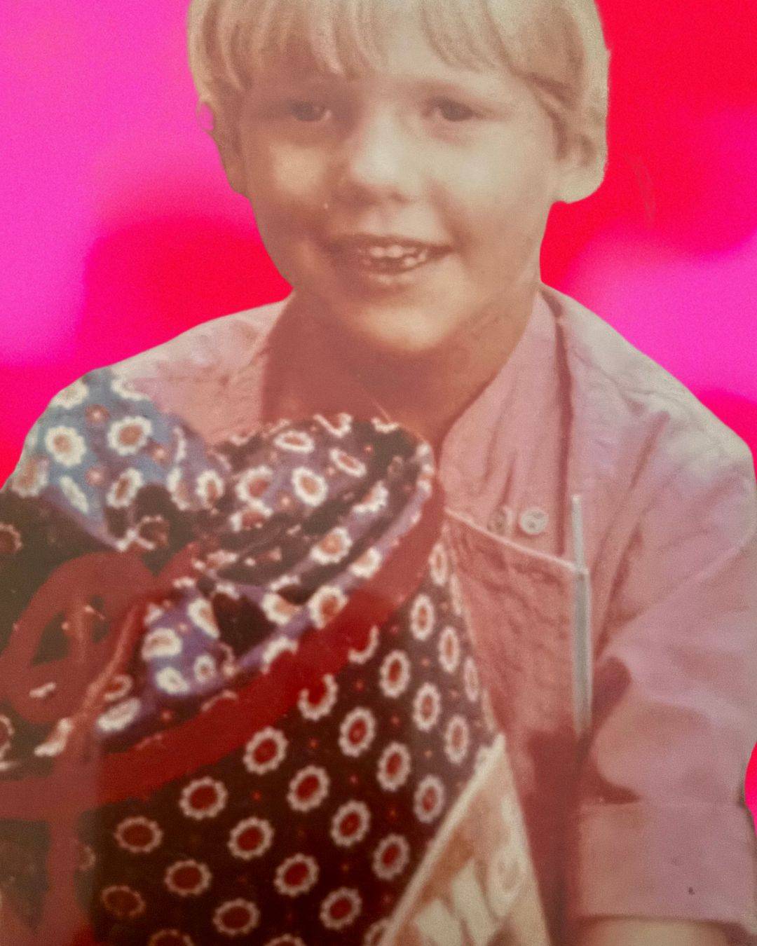Ein altes Kinderfoto von Simone Lis am ersten Schultag – mit Zahnlücke, pinkem Hemd und einer bunten Schultüte in der Hand. Ein Moment voller Aufregung und Neugier, der zeigt, wo ihre erste große Lernreise begann – und niemals enden wird. 