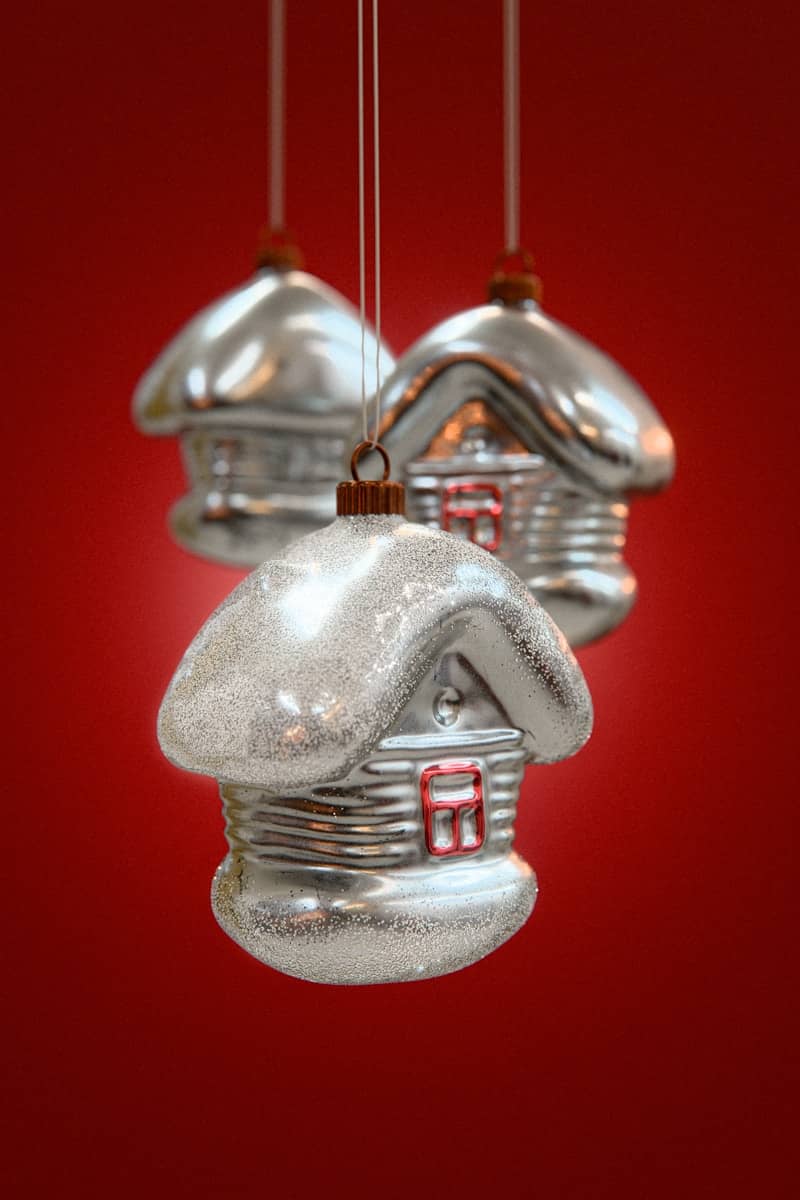 Three silver house christmas ornaments hanging