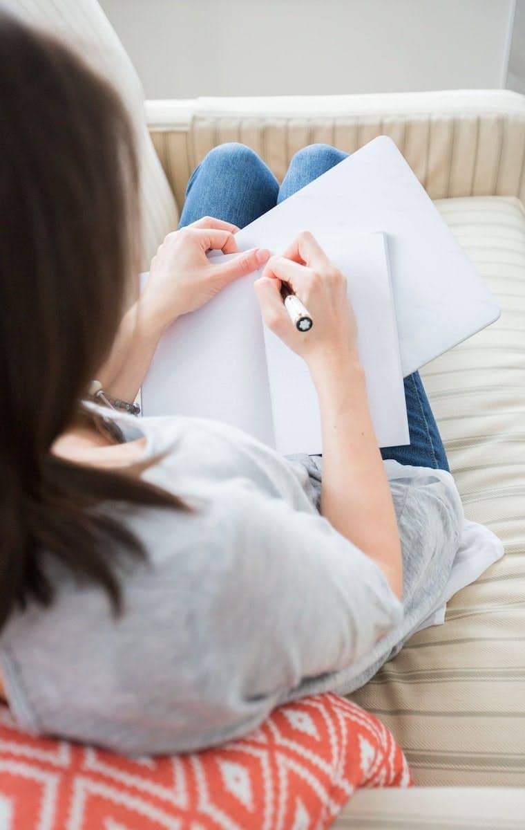 woman writing on white paper