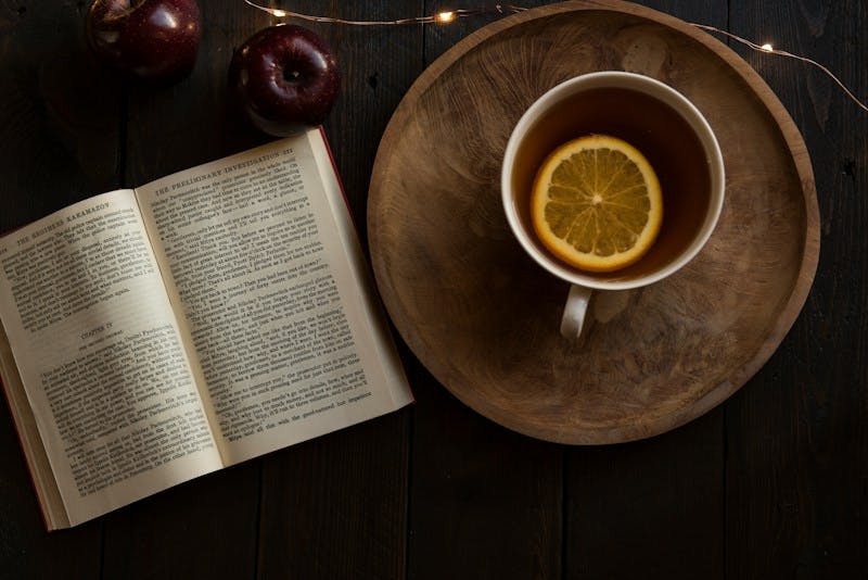 top view of open book and cup with lemon inside