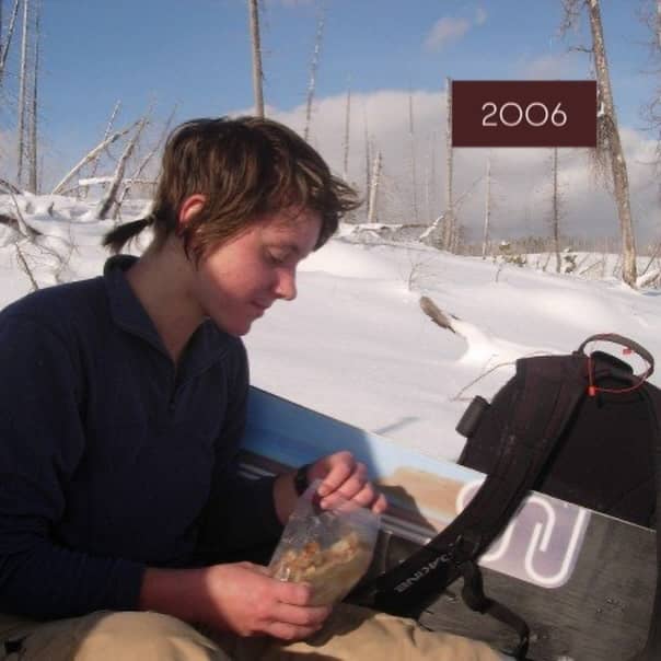 20 year old Katy eats a peanut and butter sandwich on Lolo Pass with her snowboard and backpack, the year is 2006 and Katy gave herself this haircut