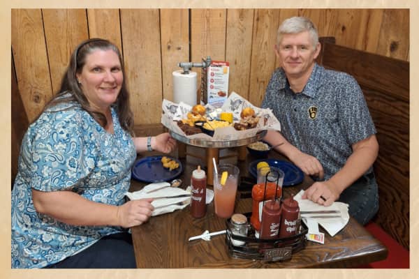 amy at neededinthehome with husband mike at famouse daves with food on table between them