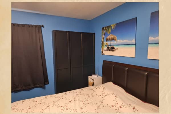 bedroom with bed ocean artwork storage cupboard