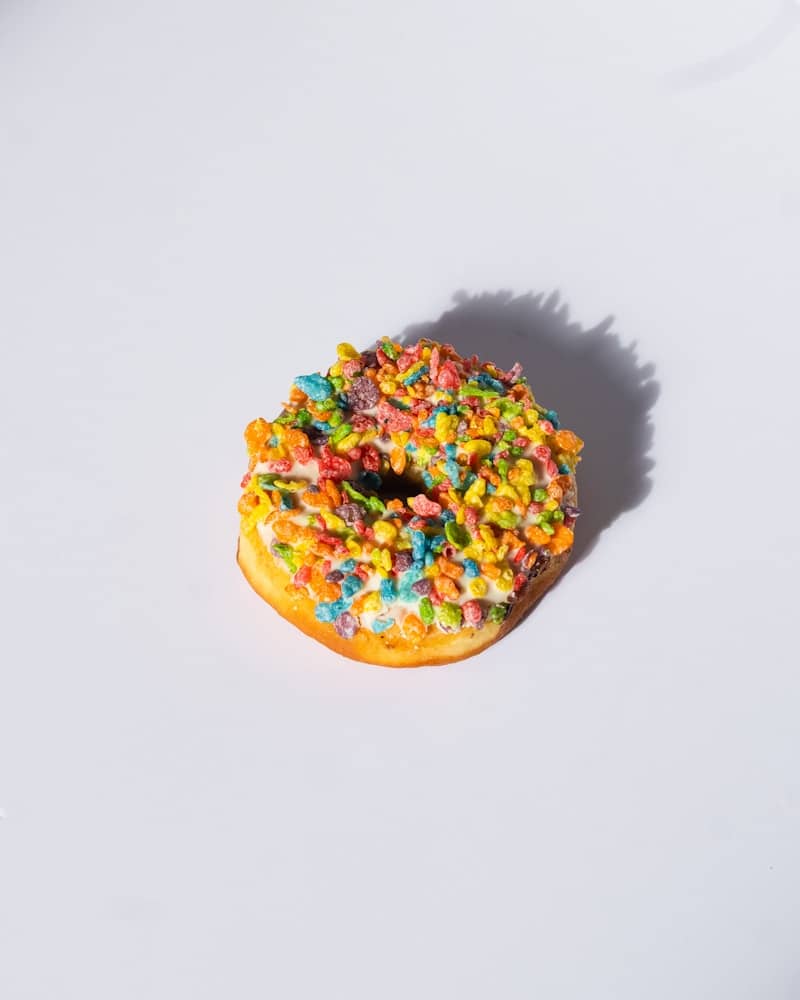 A colorful donut is ready to be eaten.