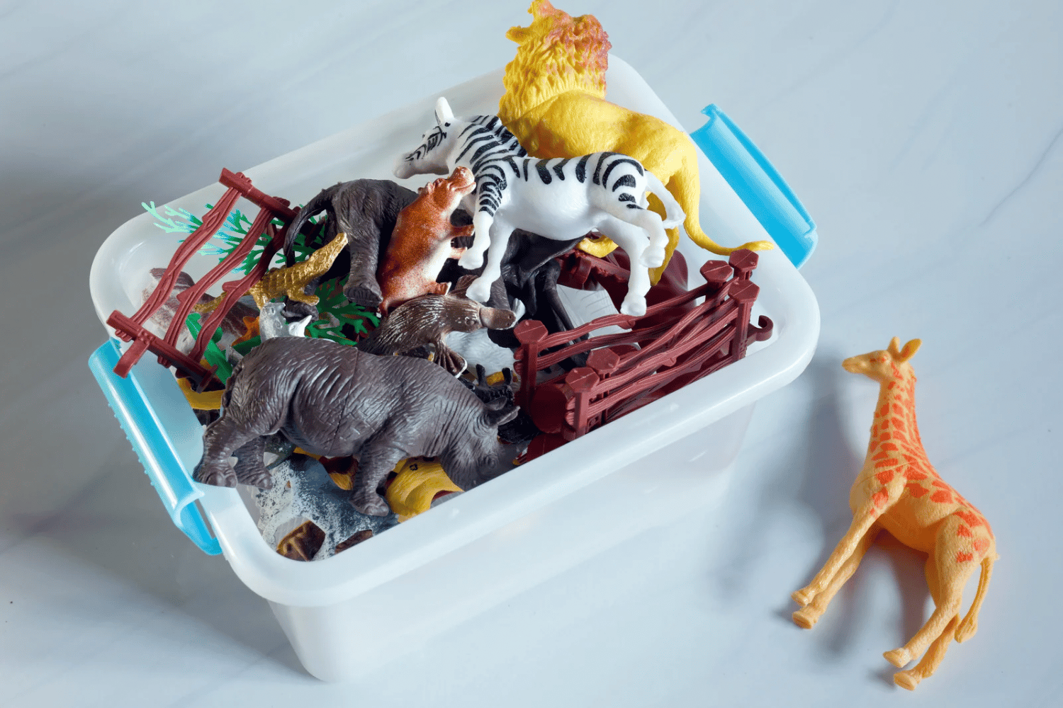 A plastic bin filled with plastic toys