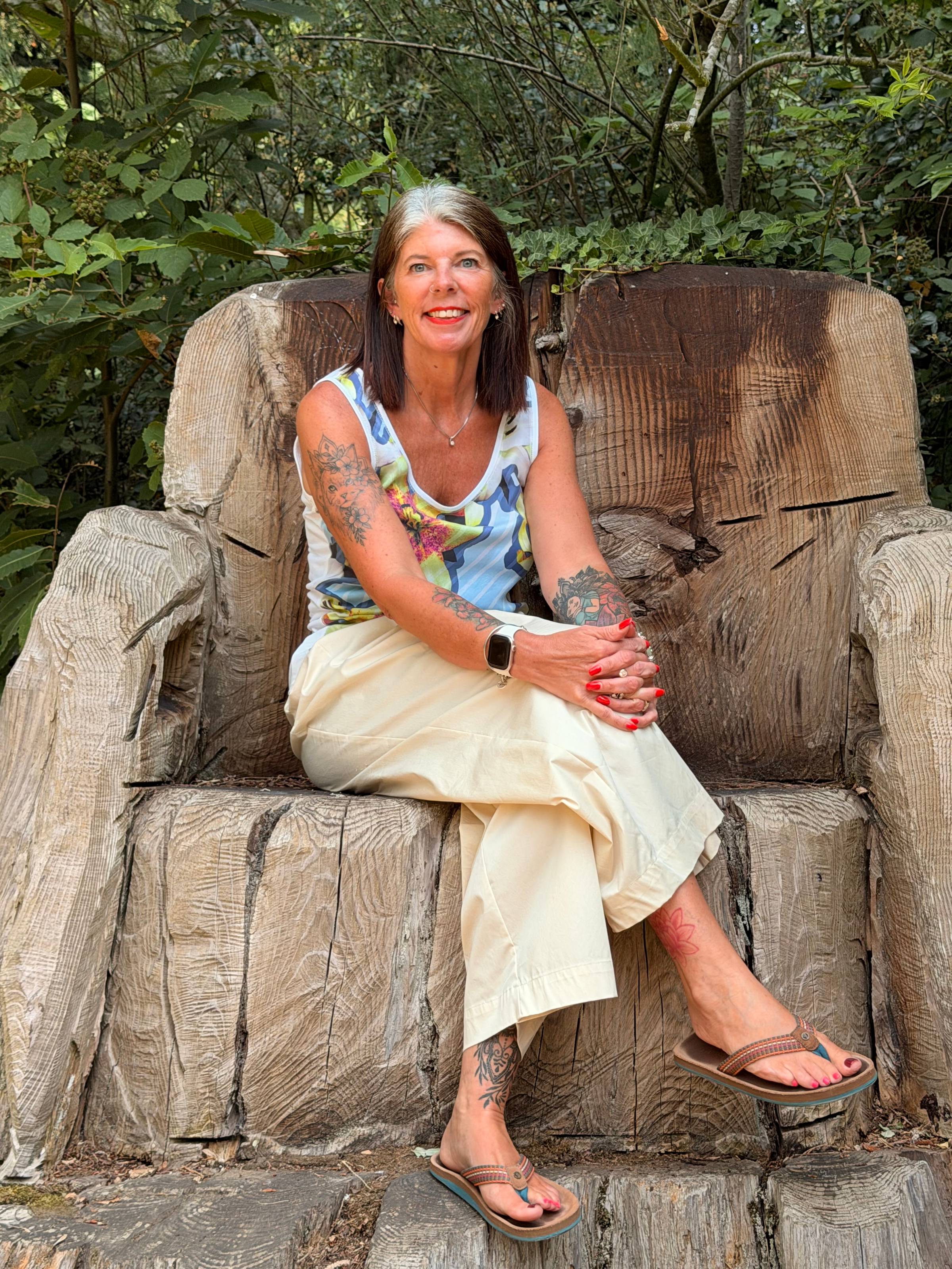 Joanne Pagett sat on a tree stump chair