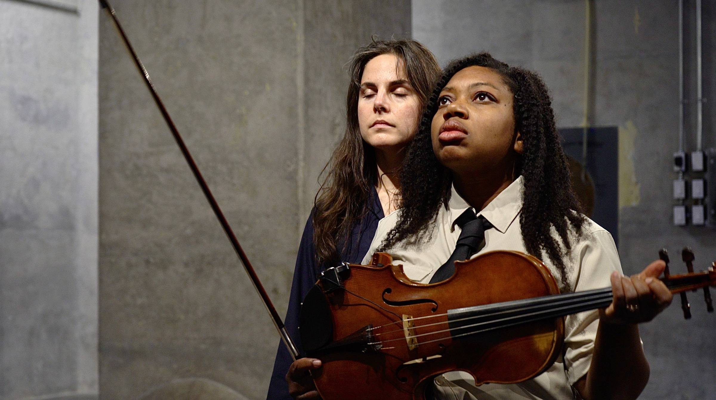 Elizabeth Standing with eyes closed; Kathryn standing looking up and off into the distance holding her viola and bow