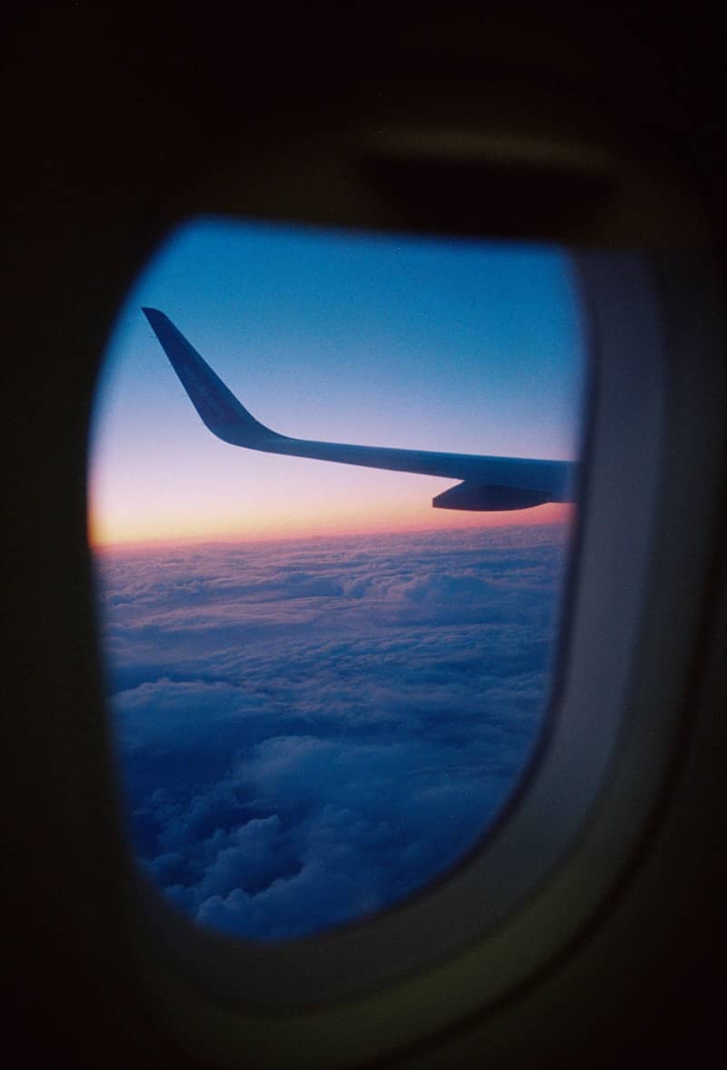 Airplane wing and clouds seen from a window.