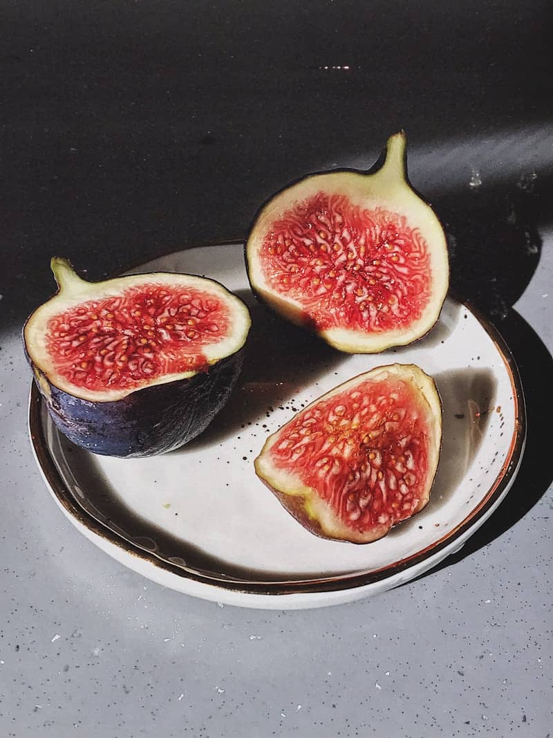 Fresh figs halved and quartered on a plate.