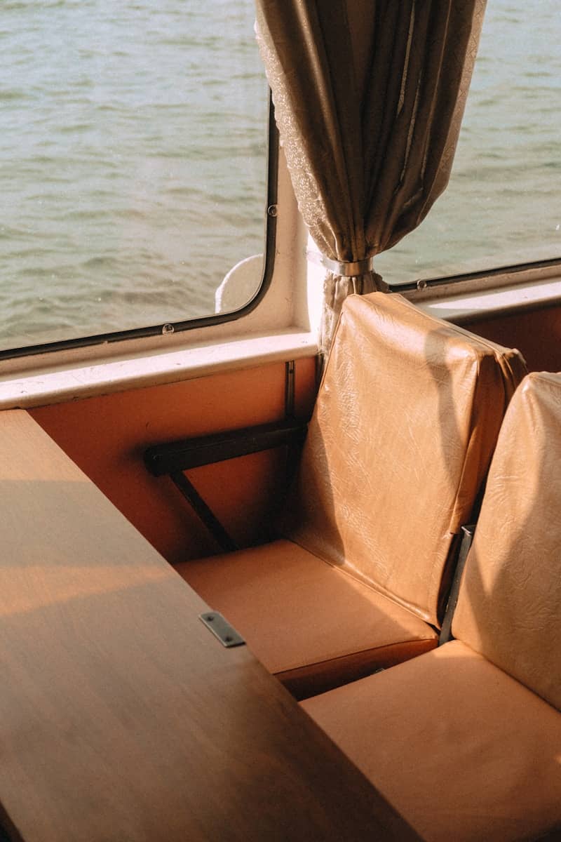Interior view of a boat with seats and window.