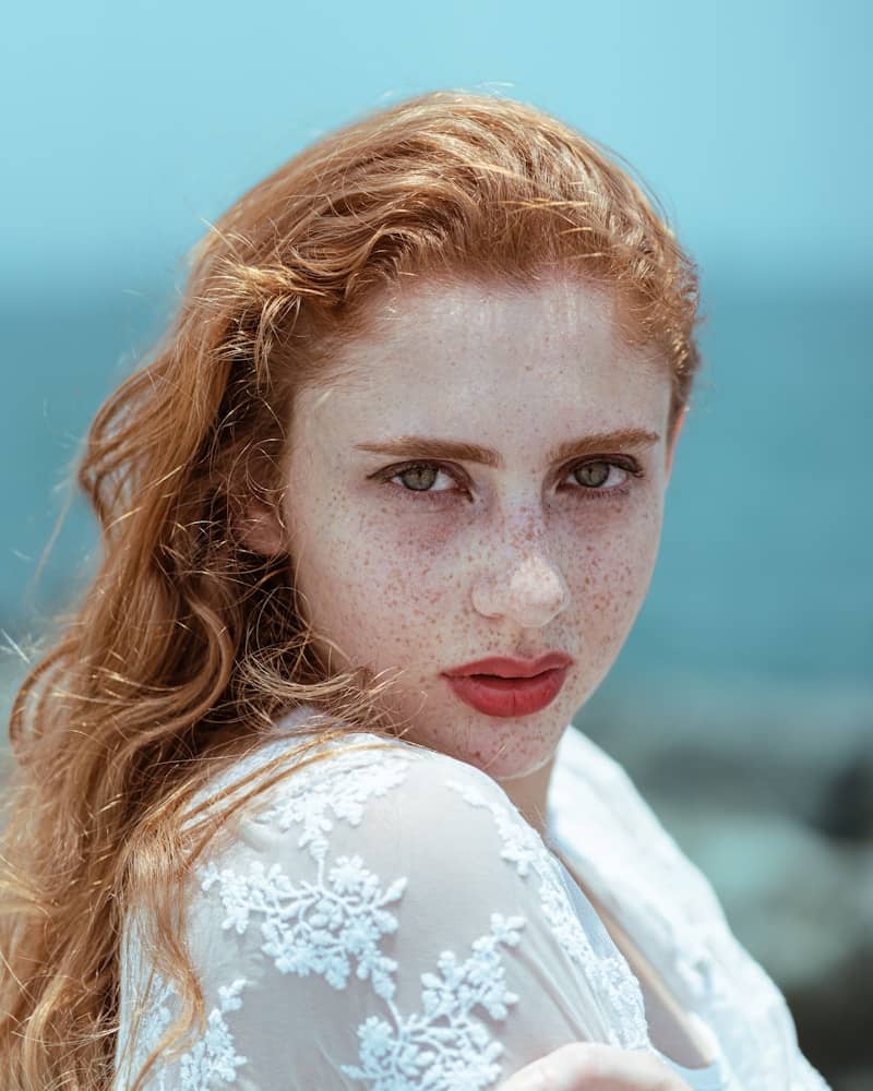 Red-haired woman gazes intently at the camera.