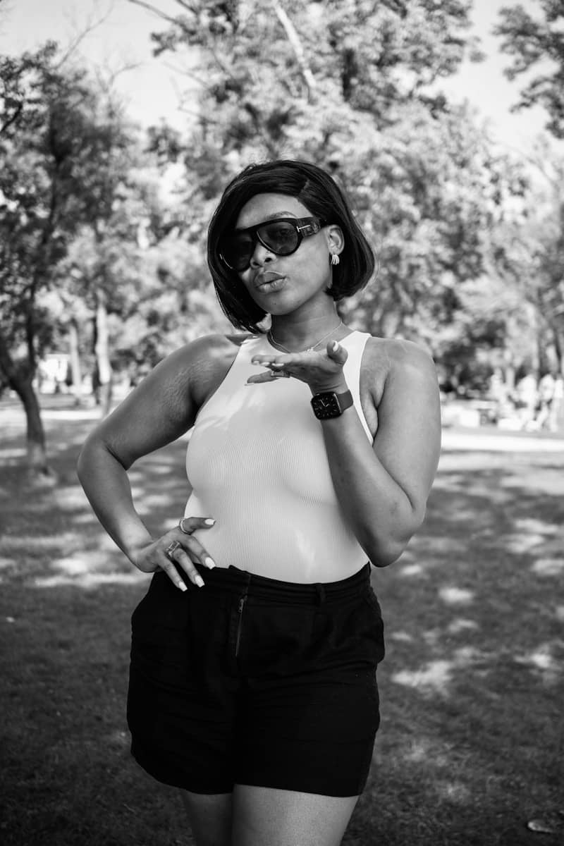 Woman blows a kiss while posing outdoors.