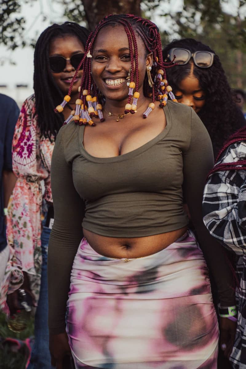 Young woman with braided hair smiling at an outdoor event