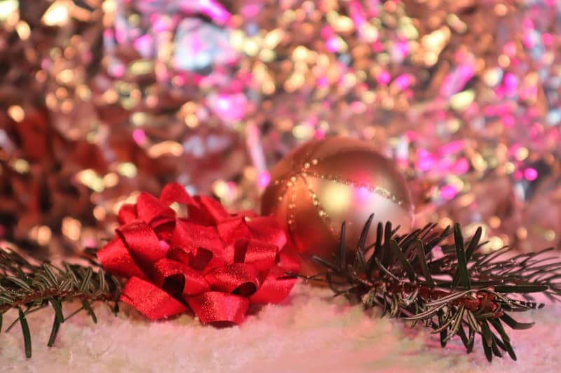 Red bow and ornament with pine needles on snow
