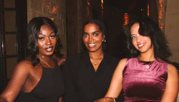 Three women smiling and posing for a photo.