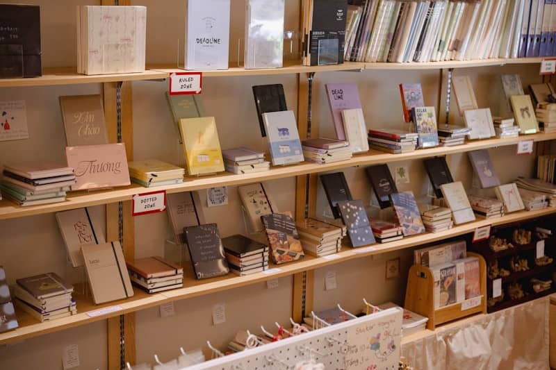 Numerous books and notebooks displayed on wooden shelves.