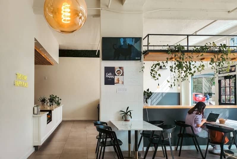 A modern cafe interior with people and plants.